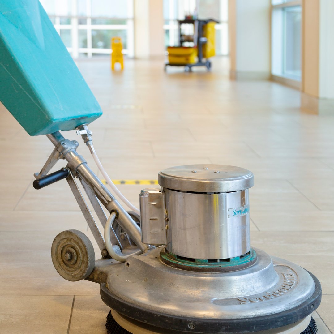 Cleaning team maintaining polished office lobby and workstations during evening commercial service visit